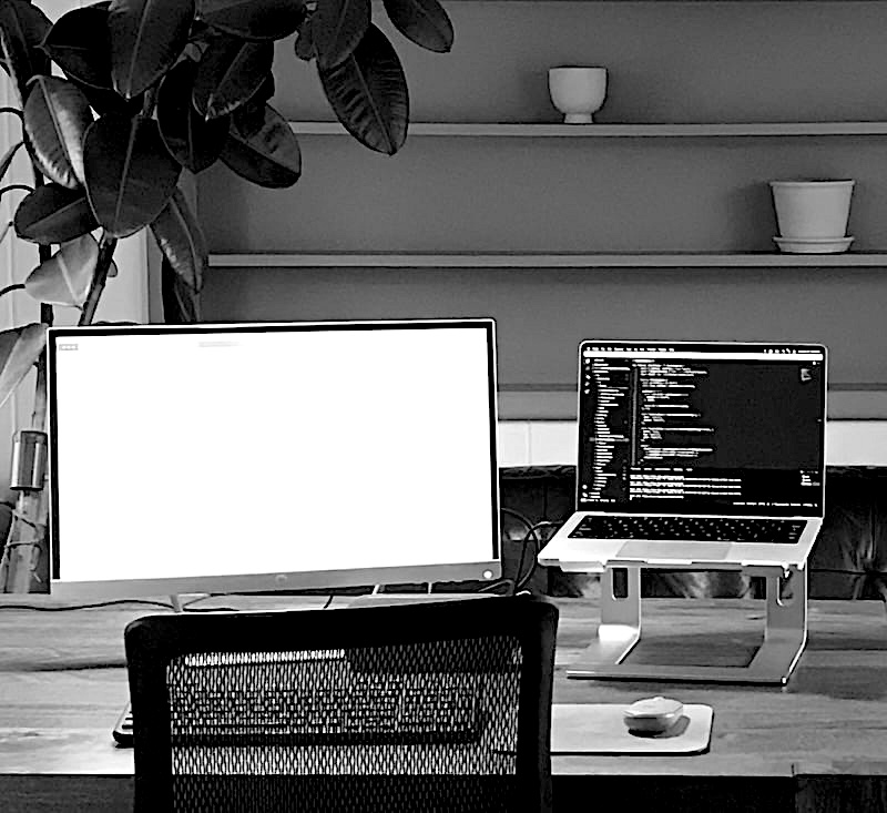 Desk with laptop, monitor, and keyboard.